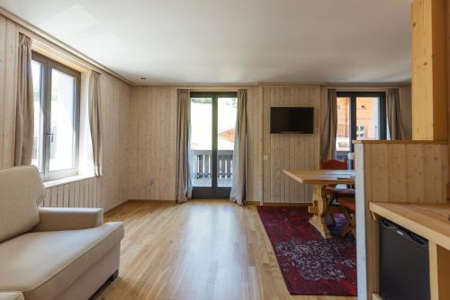 een woonkamer met een bank en een tafel bij Hotel Sanetsch in Gsteig