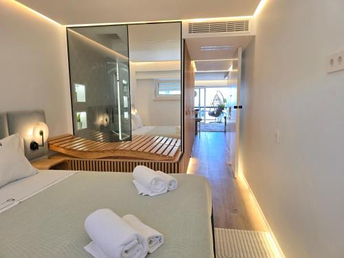 ein Schlafzimmer mit einem Bett, auf dem zwei Handtücher liegen in der Unterkunft Caparica Luxury Apartment by HOST-POINT in Costa da Caparica