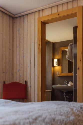 ein Schlafzimmer mit Bett und Waschbecken in der Unterkunft Hotel Sanetsch in Gsteig