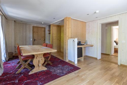een eetkamer met een tafel en een koelkast bij Hotel Sanetsch in Gsteig