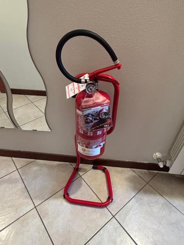 a fire extinguisher is attached to a wall at lacasadikira in Lucca