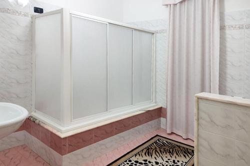 a white bathroom with a shower and a sink at Le Muse in Sogliano Cavour