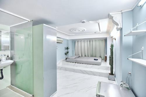 a bathroom with a bed and a shower and a sink at H2T Hotel Center BuiVien in Ho Chi Minh City