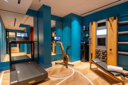 a gym with blue walls and a treadmill at Urban Hive Milano in Milan