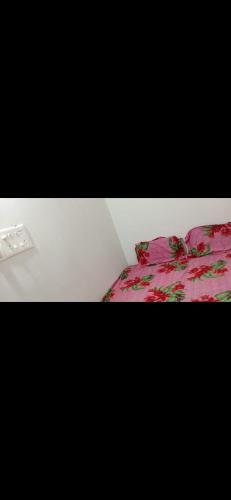 a bedroom with a bed with a pink comforter at Shree Shyam Guest House in Nagpur