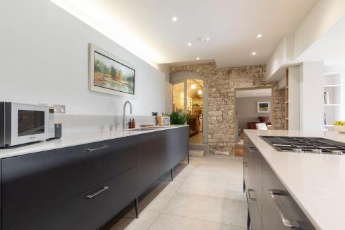 a kitchen with a counter top and a stove top oven at Cotswold Hillside Retreat with Stunning Views in Nailsworth