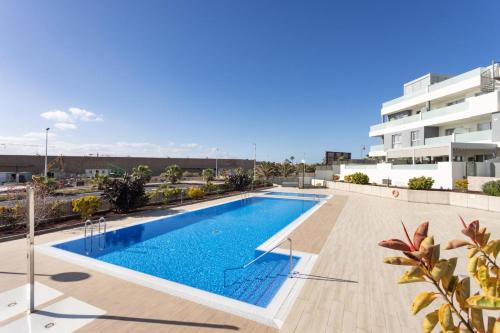 a swimming pool on the roof of a building at La Tejita, comfortable one-bedroom apartment in El Médano