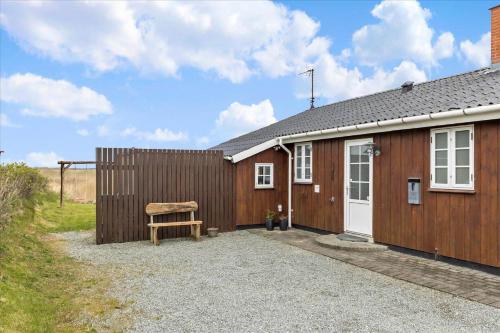 a small house with a wooden fence and a bench at 0065-Romo-Lakolk-165 in Lakolk