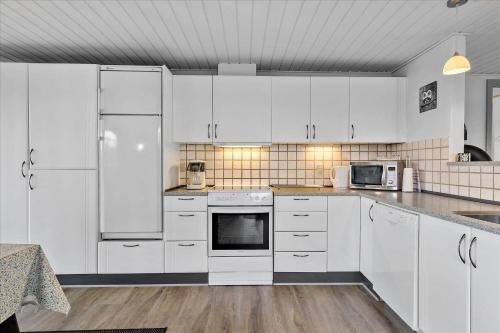 a white kitchen with white cabinets and appliances at 0065-Romo-Lakolk-165 in Lakolk