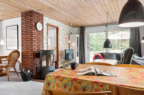 a living room with a table and a fireplace at 0413-Romo-Skovskaden-13 in Mølby