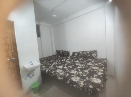 a small bedroom with a bed and a sink at Shree Shyam Guest House in Nagpur