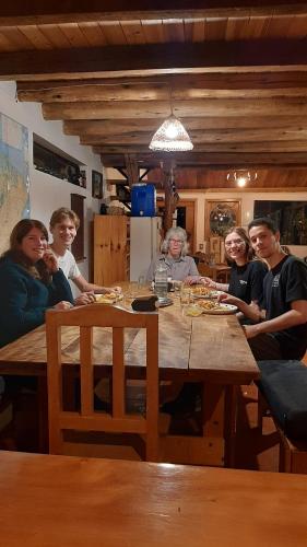 a group of people sitting around a wooden table at The Black Sheep Inn in Chugchilán