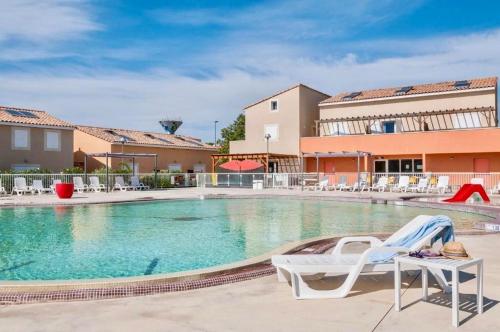 a pool at a hotel with chairs and a table at Villa F2 piscine et jardin - Saint-Cyprien in Saint-Cyprien
