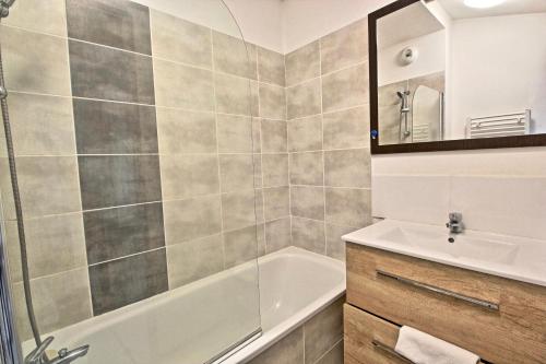 a bathroom with a shower and a tub and a sink at Villa F2 piscine et jardin - Saint-Cyprien in Saint-Cyprien