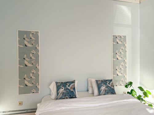 a bedroom with a bed with birds on the wall at Timuti Art Guesthouse in Tallinn