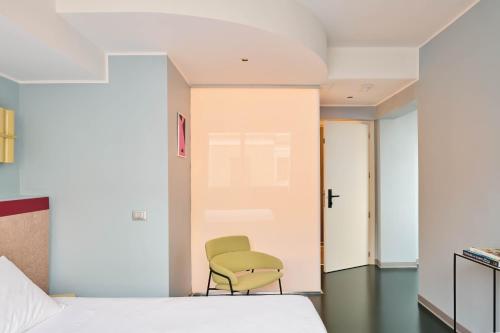 a bedroom with a green chair next to a bed at Moderno Hotel Roma in Rome