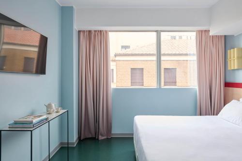 a bedroom with a bed and a large window at Moderno Hotel Roma in Rome