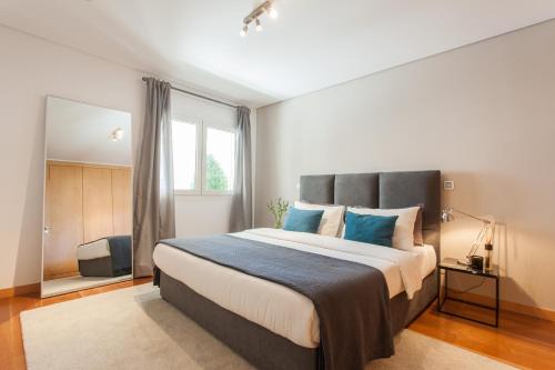 een slaapkamer met een groot bed met blauwe kussens bij Living Graça in Lissabon