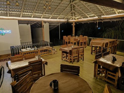 an empty restaurant with wooden tables and chairs at NAVARATHNA International resort in Sollebail