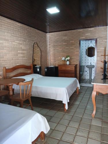a bedroom with two beds and a table and a sink at Aluguel de suítes praia do frances in Marechal Deodoro