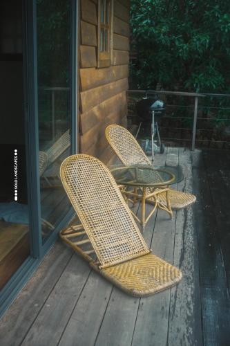 two wicker chairs sitting on a porch at Payana Kampot in Kampot