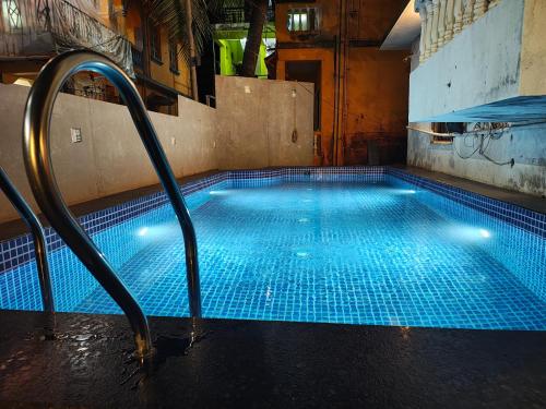 a swimming pool with blue tiles on the floor at Harsh angel holiday homes in Calangute