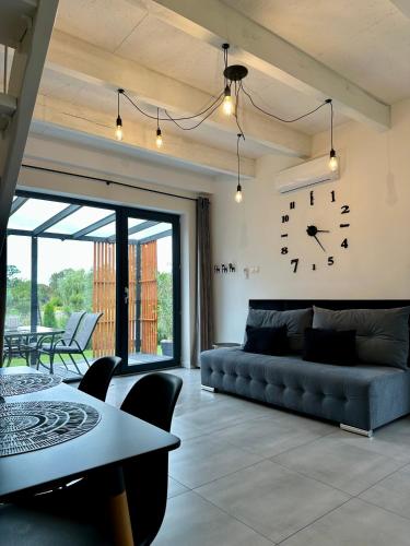 a living room with a couch and a clock on the wall at M&M House in Okuninka