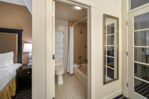 a bathroom with a bed and a toilet and a tub at Best Western Plus Palm Court Hotel in Davis