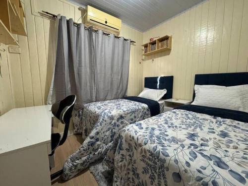 a hotel room with two beds and a window at Cantinho da Iraci in Foz do Iguaçu