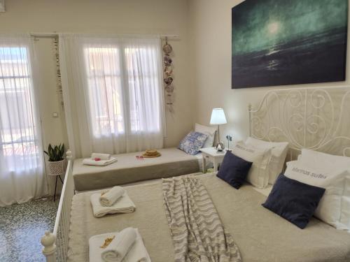Un dormitorio con dos camas con toallas encima. en Marinos Suites, en La Canea
