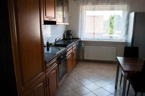 a kitchen with a stove and a sink and a window at Schöne, große Wohnung mit 3 Betten in Bramsche