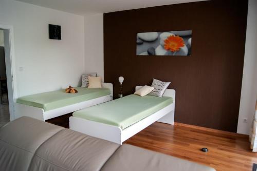 a living room with two green and white couches at Schöne, große Wohnung mit 3 Betten in Bramsche