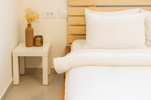 a bedroom with a bed and a side table at Revava Country Stay in Migdal Afeq