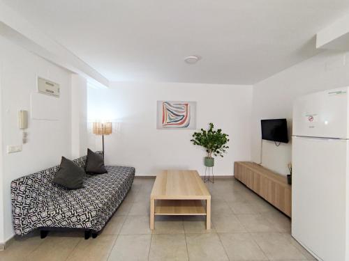 een woonkamer met een bank en een tafel bij Apartamentos Gandía Centro 3000 in Gandía
