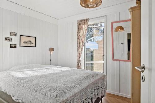a white bedroom with a bed and a window at 0090-Romo-Lakolk-256 in Lakolk