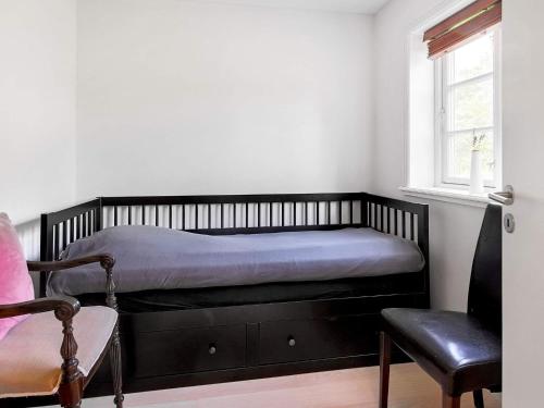 a bedroom with a bed and a chair and a window at 4 person holiday home in Skibby in Skibby