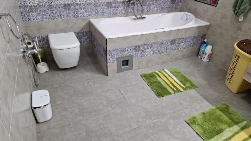 a bathroom with a tub and a toilet and a sink at grand appartement la roche in Banzart