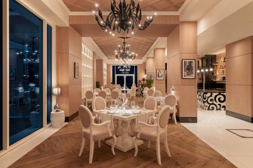 a dining room with a table and chairs and a chandelier at Rixos Marina Abu Dhabi in Abu Dhabi