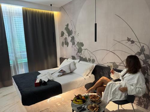 a woman sitting in a chair in a hotel room at Relais Stibbert Florence in Florence