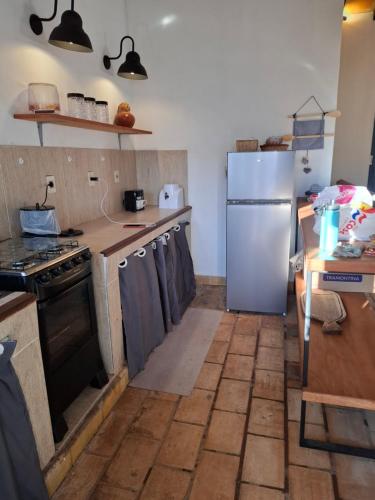 a kitchen with a refrigerator and a counter top at Casa colonial a metros del arroyo Piribebuy in Piribebuy