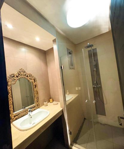 a bathroom with a sink and a shower with a mirror at kenitra appartement premium in Kenitra