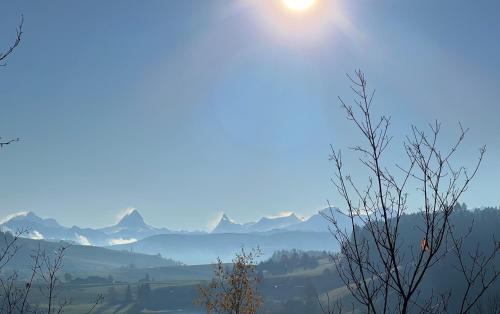 a view of a valley with the sun in the sky at Restaurant Hotel Rüttihubelbad in Walkringen