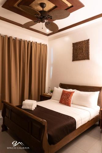 a bedroom with a bed with a ceiling fan at Spacio Caliraya Bed & Breakfast in Lumban