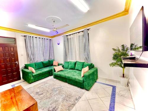 a living room with a green couch and a table at Queens Luxury 2 Bedroom Mombasa in Mombasa