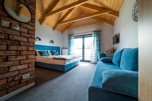 a living room with a blue couch and a brick wall at U przyjaciol - Debki in Dębki