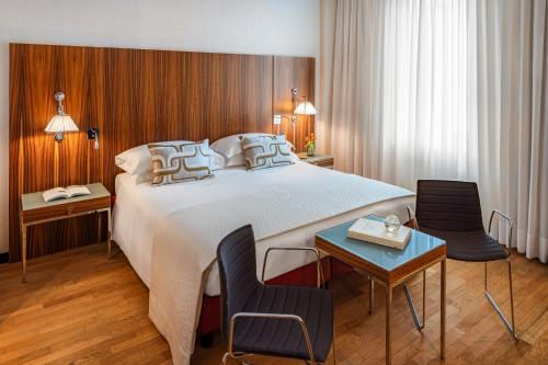 a hotel room with a large bed and a table at Starhotels Anderson in Milan