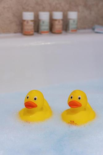 three yellow rubber ducks sitting in a bath tub at Starhotels Anderson in Milan