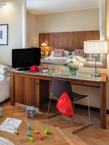 a bedroom with a bed and a desk with a bed at Starhotels Anderson in Milan