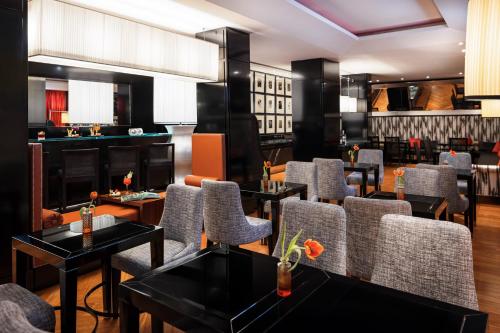 a restaurant with tables and chairs and a bar at Starhotels Anderson in Milan