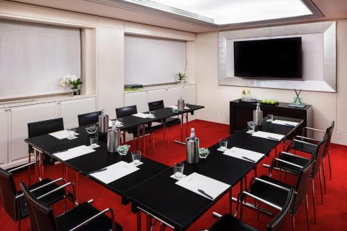a conference room with tables and chairs and a flat screen tv at Starhotels Anderson in Milan